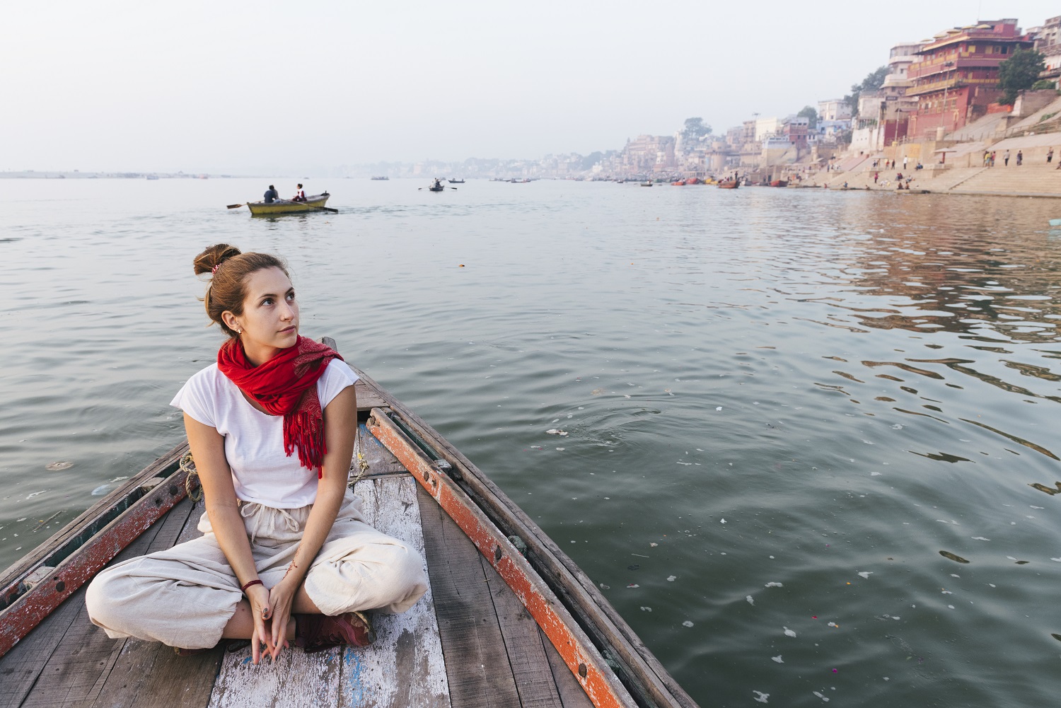 Western woman on a boat exploring the River Ganges